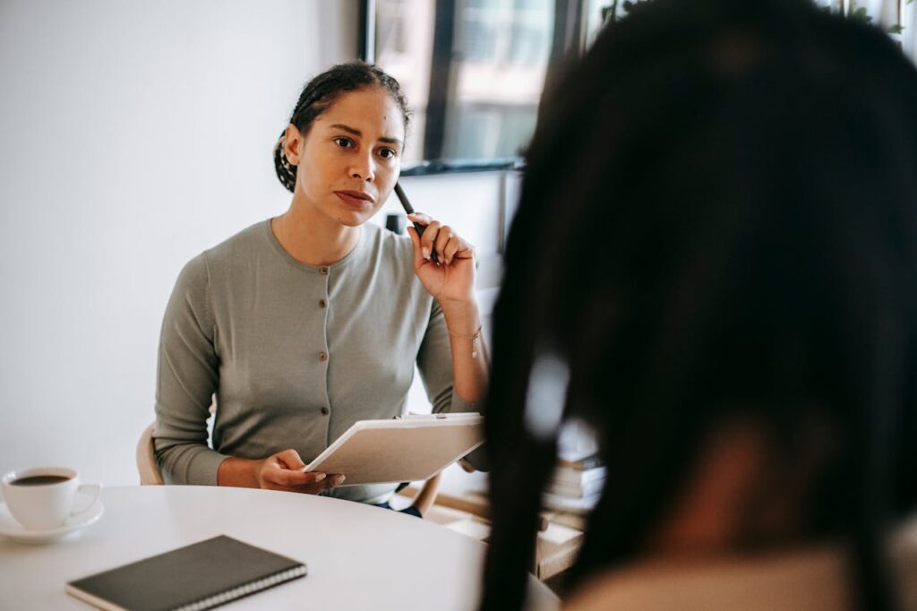 Serious ethnic psychotherapist listening to clients complains